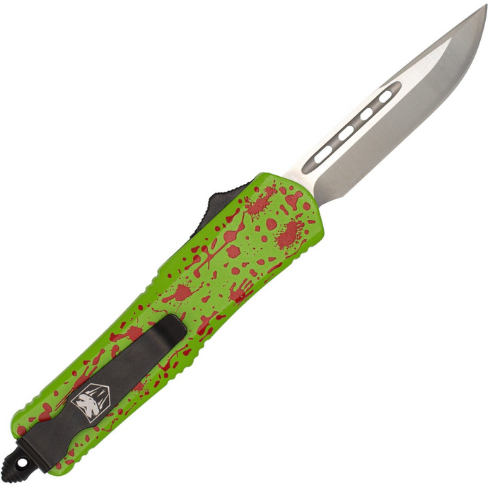 A pocket knife with a bright lime green handle featuring a red splatter pattern, a black clip, and a silver drop-point blade, shown on a plain white background.