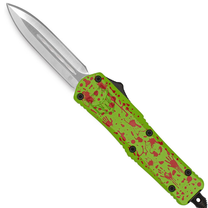 A tactical folding knife with a silver steel blade and a lime green handle featuring a red splatter pattern, shown against a plain white background.